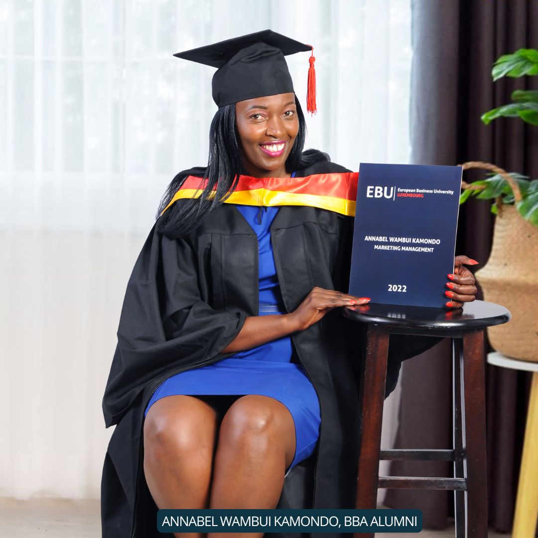 Annabelle, a proud BBA alumna from EBU, wearing graduation attire and holding her diploma.